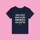 Little Gardeners Navy ABC Toddler T-Shirt featuring a colorful garden-themed ABC illustration on a soft cotton tee on a pink background