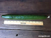 Long, slender green cucumber with a ruler
